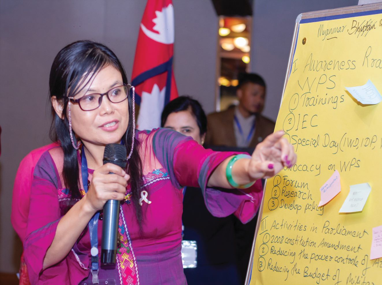 A woman leads the discussion at the seminar using a presentation board.